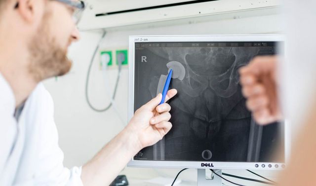 Bild eines Beckens auf einem Computerbildschirm. Ein Arzt zeigt mit einem Stift etwas auf diesem.
